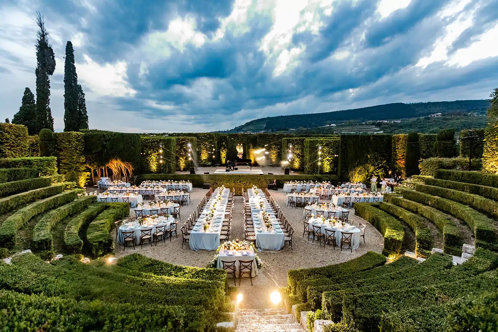Elegant dinner setup with stage in Italian villa garden