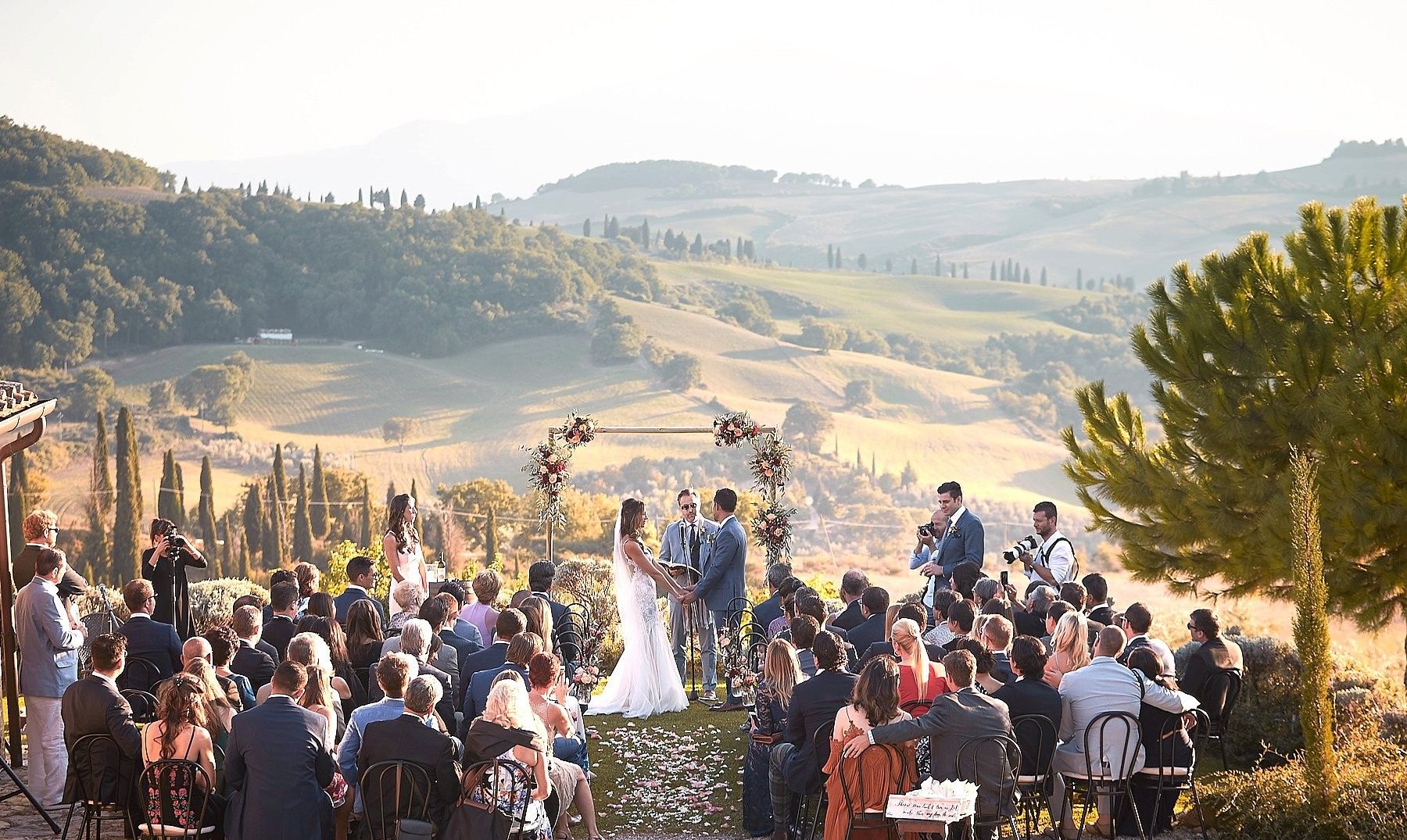Elegante bruiloftceremonie in het Italiaanse platteland met heuvels op de achtergrond